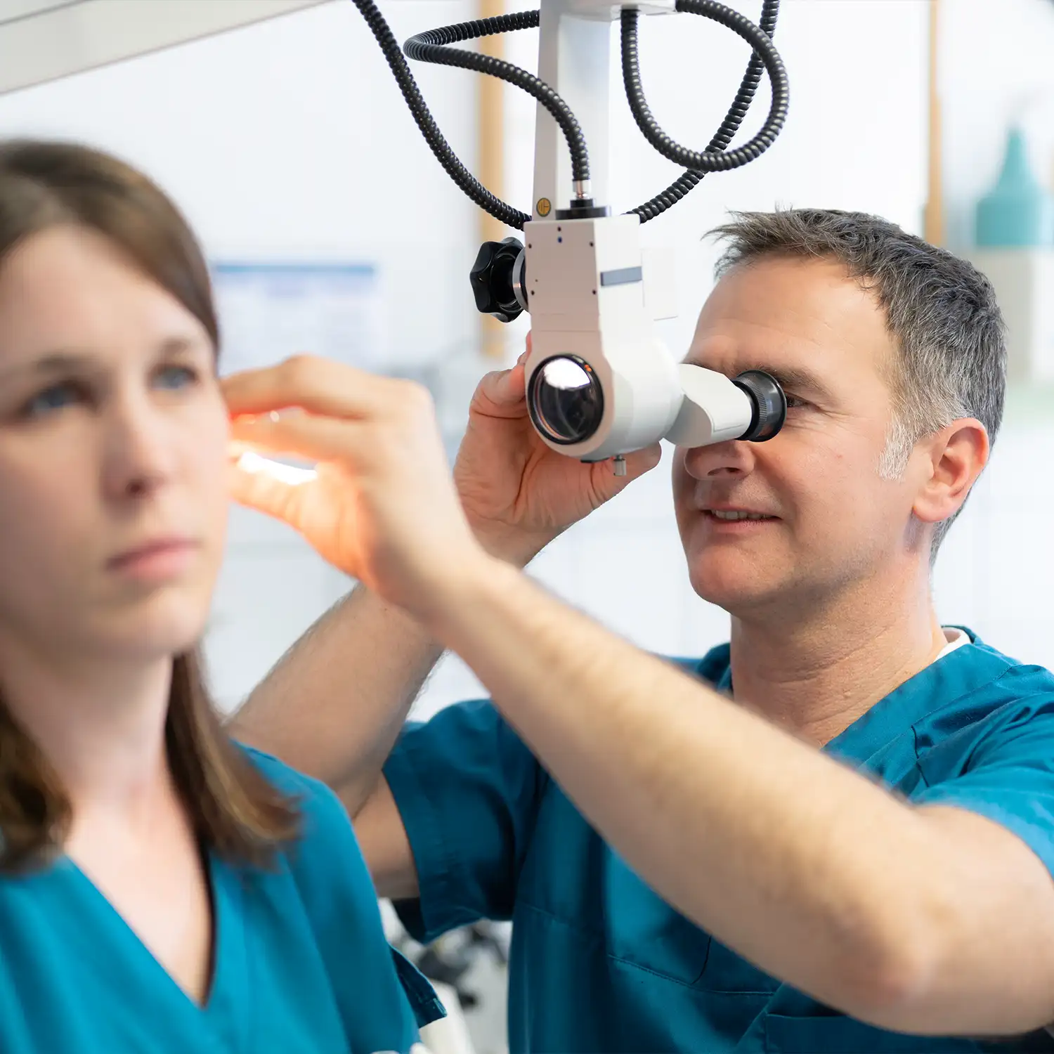 Dr. Christian Rackel untersucht eine Patientin am Ohr.
