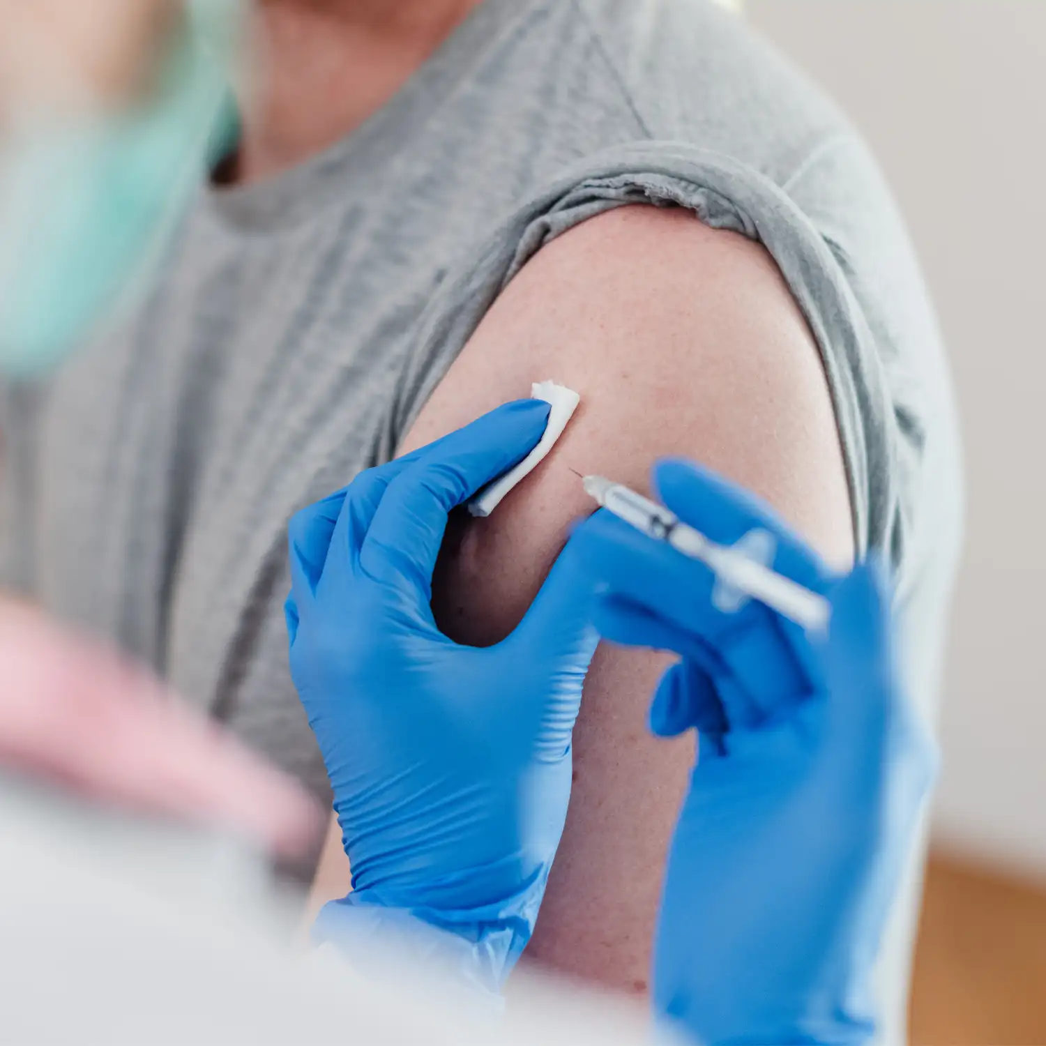 Impfungen in der Ordination Fischbach. Eine Person hat den Ärmel hochgekrempelt und wird gerade geimpft.